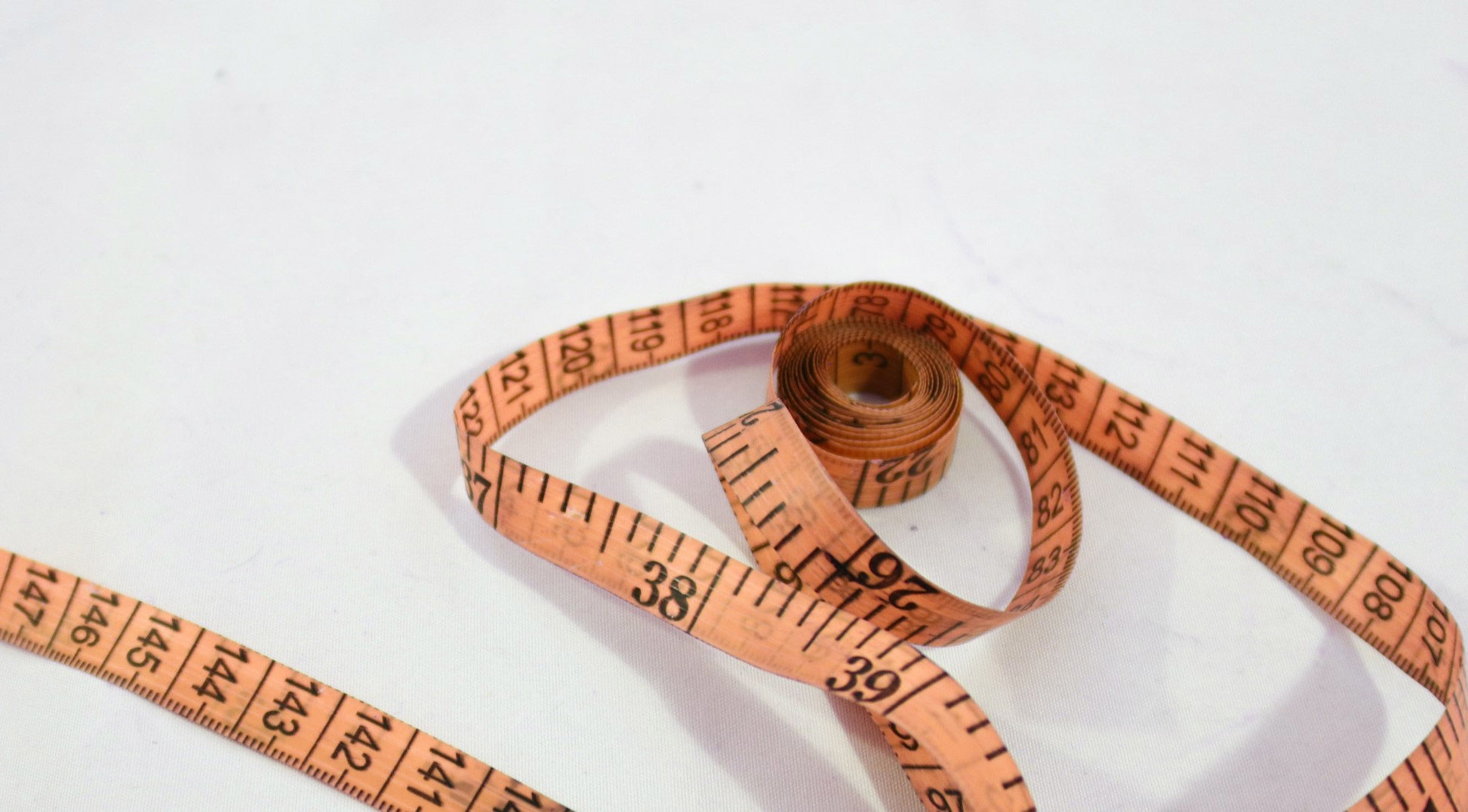 Orange measuring tape on white background
