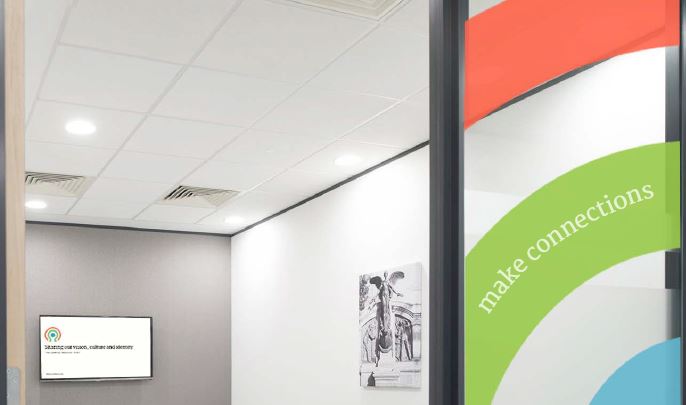 Dunhill Medical door signage leading to a room with a painting and a digital screen