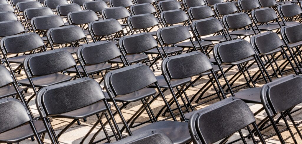 Multiple rows of empty black steel chairs