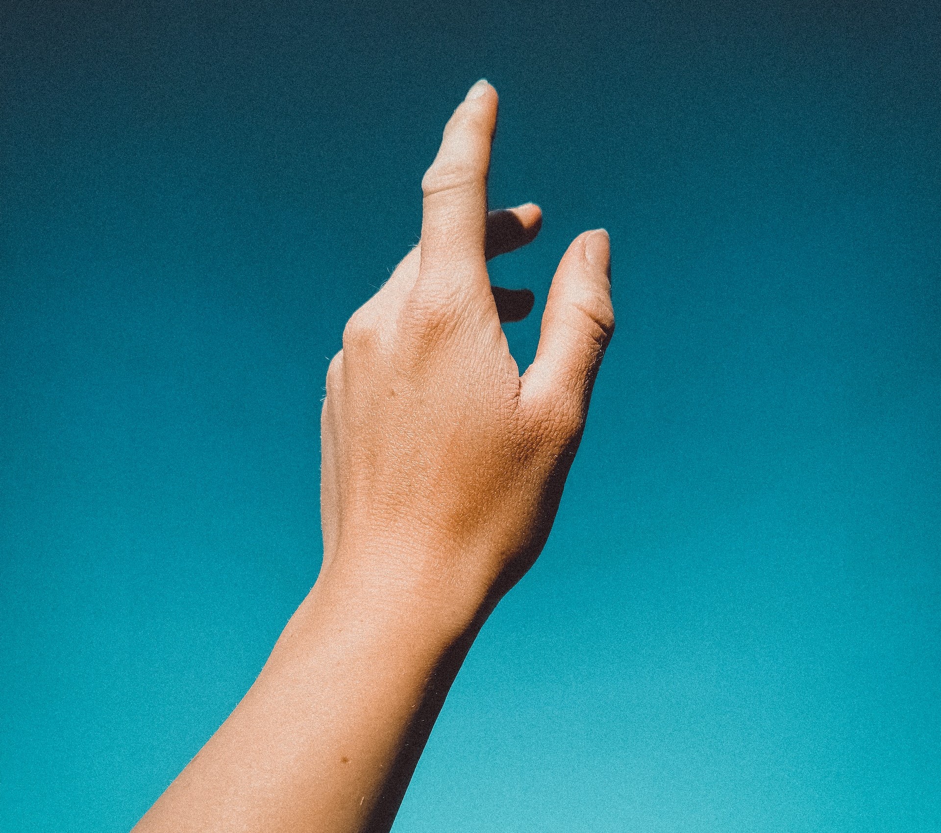 Raised hand against a blue background