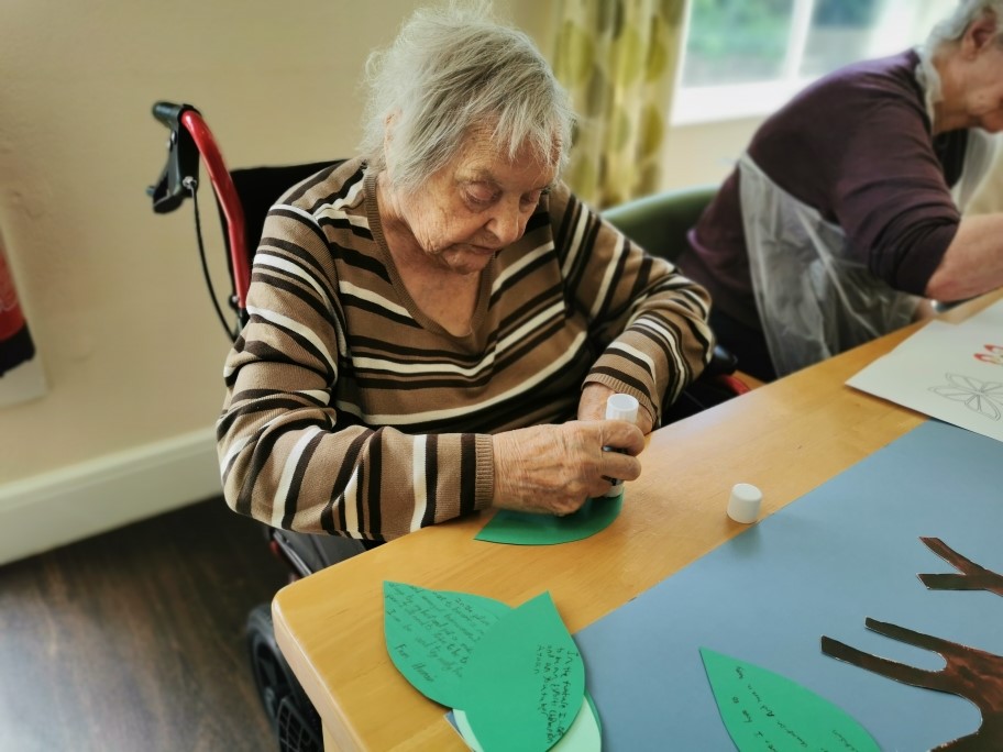 Older woman in a wheelchair engaging in a craft activity