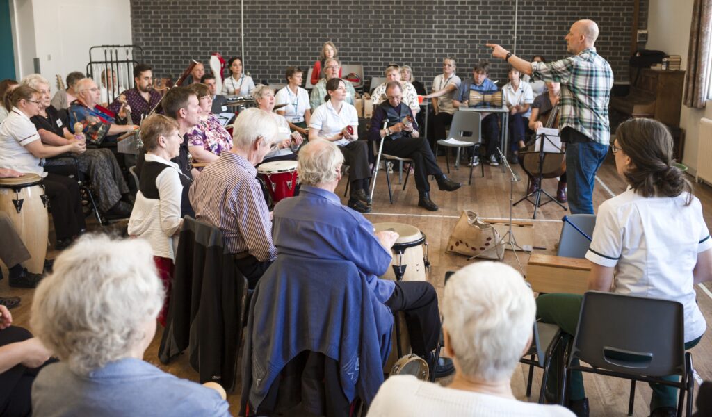 Conductor leading an orchestra of older people.